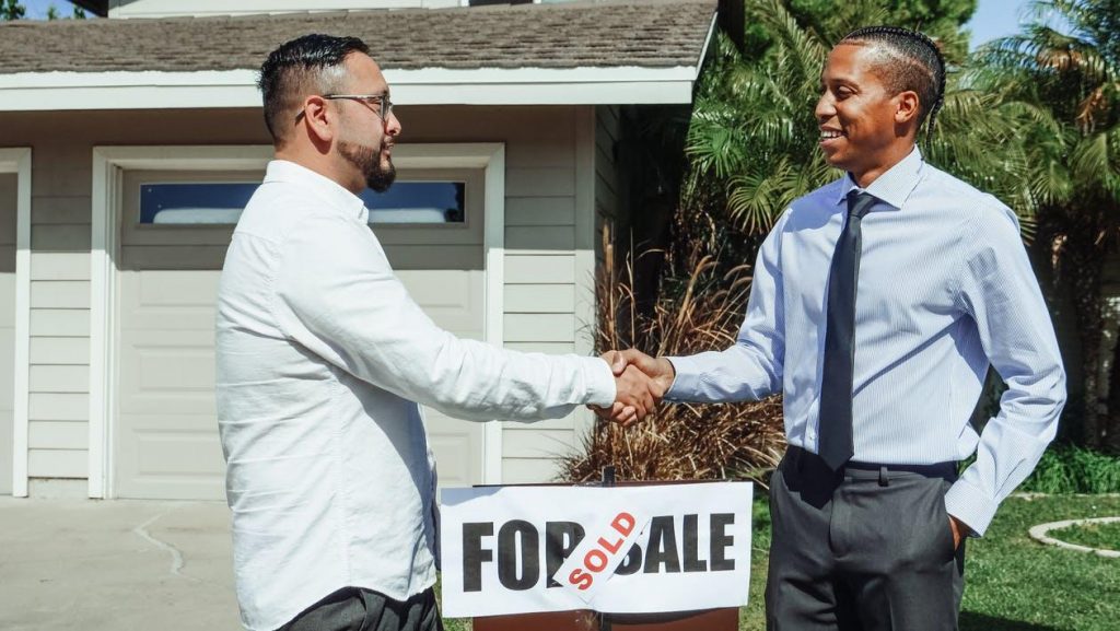 Realtor is closing the deal and shaking hands with the buyer